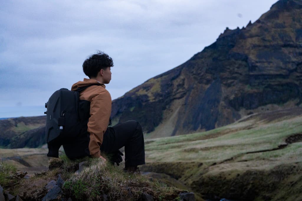 Photographer facing a basalt waterfall from behind